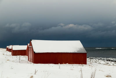 Built structure on land by sea against sky