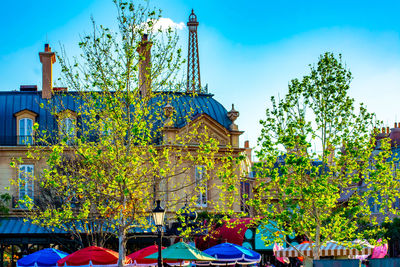 People at amusement park against blue sky