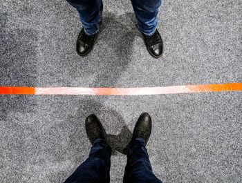 Low section of man standing on road