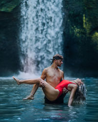 A couple at a waterfall in bali.