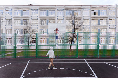 Teenager playing basketball on sport field