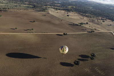 High angle view of hot air balloons flying over land