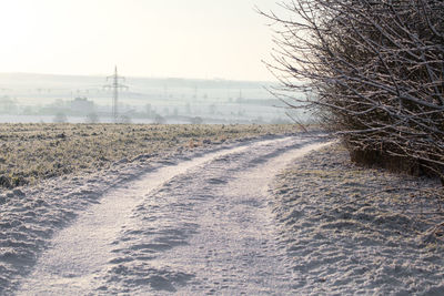 Snow covered landscape against clear sky