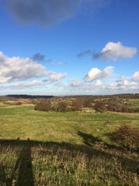 View of grassy landscape against cloudy sky