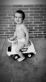 Cute boy playing with toy on floor