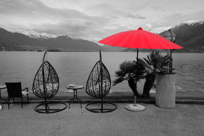 Umbrellas against mountains and lake against sky