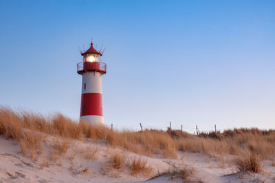 Low angle view of lighthouse at beach against clear sky