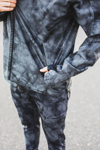 Midsection of man holding umbrella standing on street