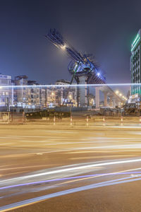 Light trails on street against sky at night