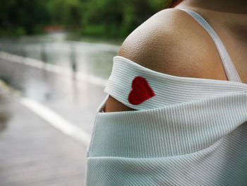 Cropped image of woman wearing off shoulder with red heart shape
