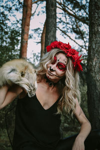 Happy halloween concept. scared horrible female sitting in special outfit, wears white clay skull.