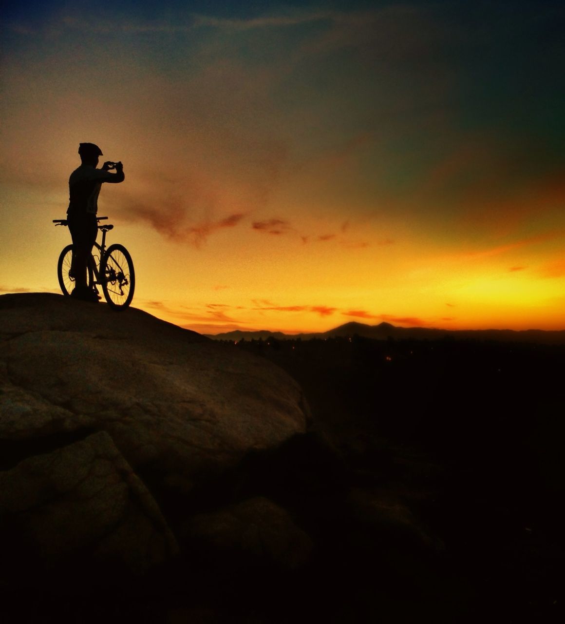 bicycle, transportation, land vehicle, mode of transport, sunset, sky, silhouette, riding, cloud - sky, scenics, tranquility, tranquil scene, cycling, nature, landscape, travel, mountain, orange color, beauty in nature