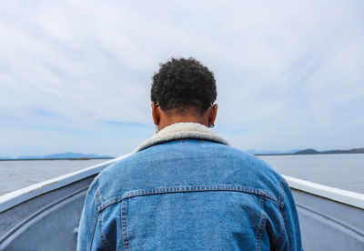 Side view of man looking at sea against sky 