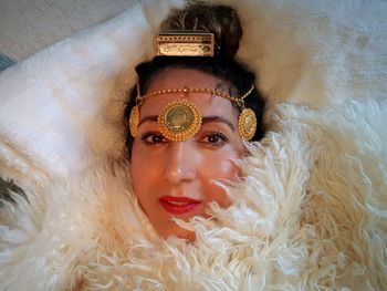 Portrait of woman lying on bed with tiara at home