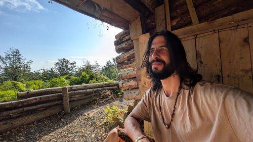 Portrait of young man standing against old building