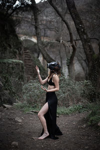 Side view of woman standing in forest