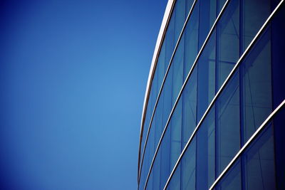 Low angle view of modern building against blue sky