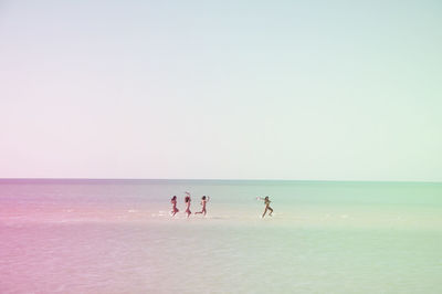 Scenic view of women in sea against sky