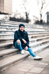 Portrait of man sitting on staircase