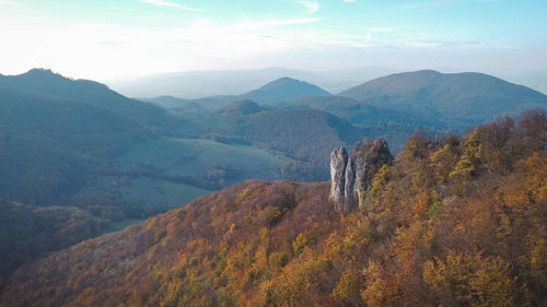 Rock surrounded by autumn colourful forest during november in slovak forests in eastern europe
