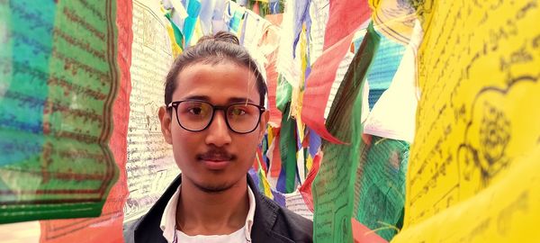 Portrait of young man amidst prayer flags