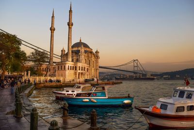 Boats in river with city in background