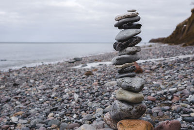 Stack of pebbles on beach against sky