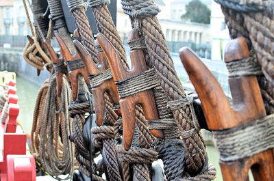 Close-up of wooden equipment tied up to rope on boat