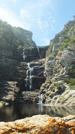 Scenic view of waterfall against sky