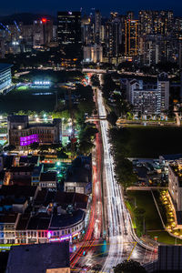 High angle view of illuminated street amidst buildings at night