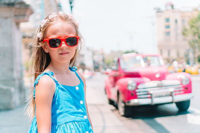 Portrait of woman wearing sunglasses standing in city