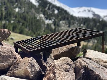 Close-up of barbecue structure over stones at the mountain against sky