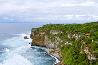 Scenic view of sea by cliff against sky