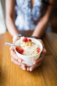 Close-up of hand holding ice cream in bowl