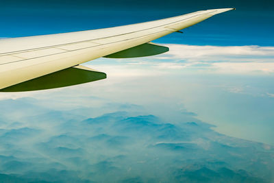 Aerial view of aircraft wing against sky