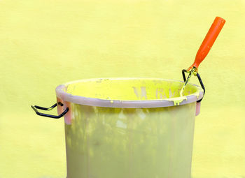 Close-up of water in container against yellow background