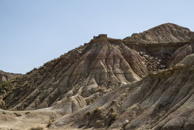 Low angle view of rocky mountain against clear sky