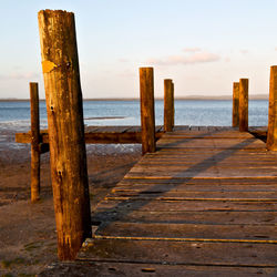 Wooden pier on sea against sky