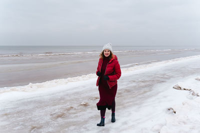 Winter walk along the sea, a woman walks and smiles