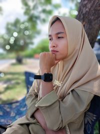 Portrait of young woman sitting outdoors