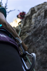 Midsection of person with rope on rock