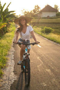 Rear view of man riding bicycle on field