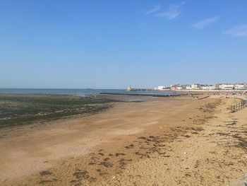 Scenic view of beach against blue sky