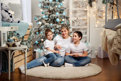 Portrait of happy family. mom and kids decorate the christmas tree