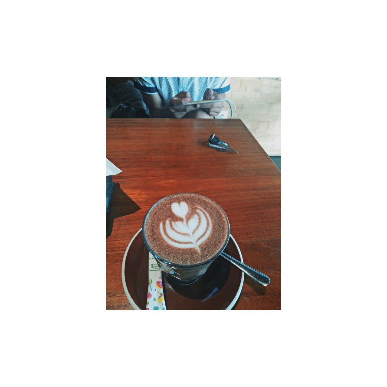 COFFEE CUP ON TABLE AGAINST WHITE WALL