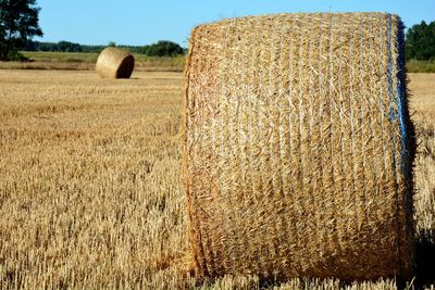 Hay bales on field against sky