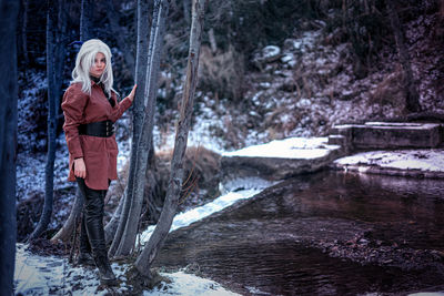 Rear view of woman standing in forest