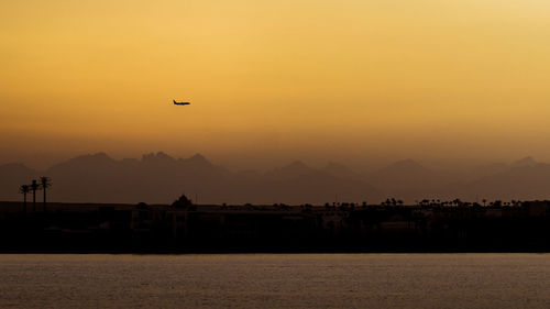 Scenic view of sea against orange sky