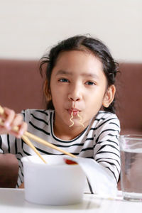 Portrait of cute girl sitting on table