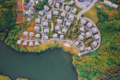 High angle view of buildings by river in city during autumn